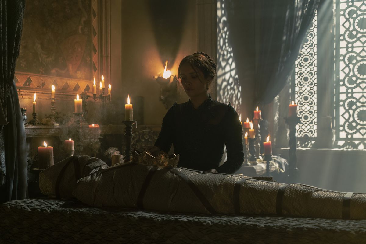 Olivia Cooke nei panni di Alicent Hightower in piedi sopra il corpo avvolto di re Viserys Targaryen in House of the Dragon