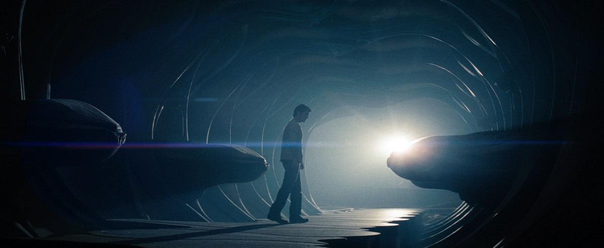 Henry Cavill nei panni di Clark Kent si trova su una nave kryptoniana, con strani oggetti alieni intorno a lui e una luce sullo sfondo, in Man of Steel