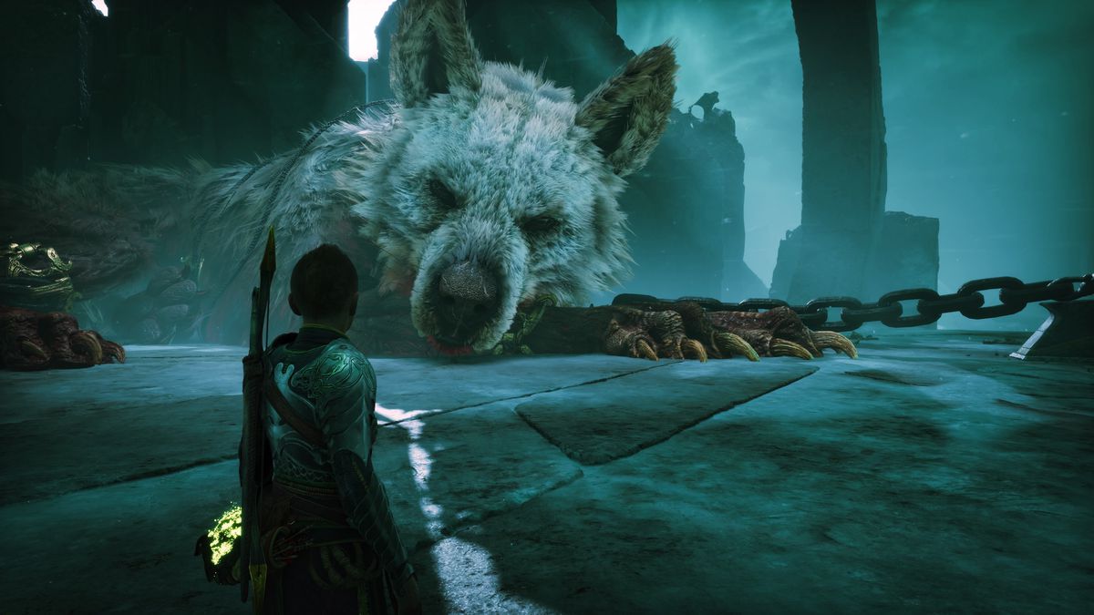 Atreus guarda un enorme lupo addormentato, che sembra essere incatenato a qualcosa con catene giganti, in God of War Ragnarok.