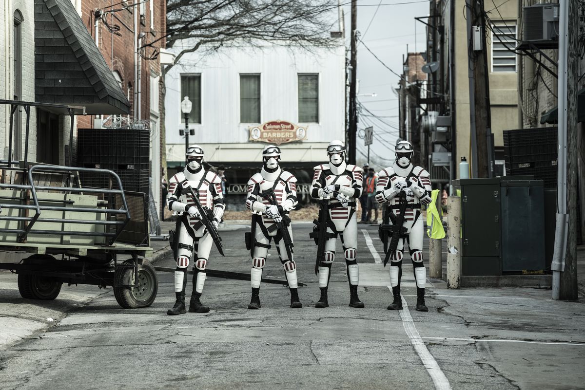 Quattro persone vestite quasi come Stormtroopers su una strada deserta con le pistole