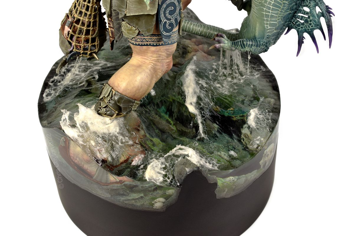 Un primo piano estremo dell'acqua - resina versata sulla base - di due grandi figure in un diorama che combattono.  Le onde sono accuratamente scolpite e l'acqua è limpida ma spumosa in cima.