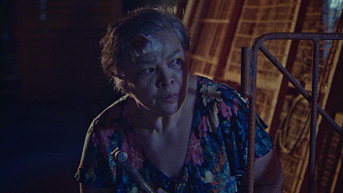 Leonor (Sheila Francisco), un'anziana filippina con una benda insanguinata sulla testa, si nasconde fuori di notte con aria sospettosa in Leonor Will Never Die