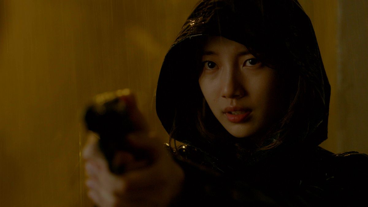 Bae Suzy indossa un impermeabile e impugna una pistola in Vagabond.