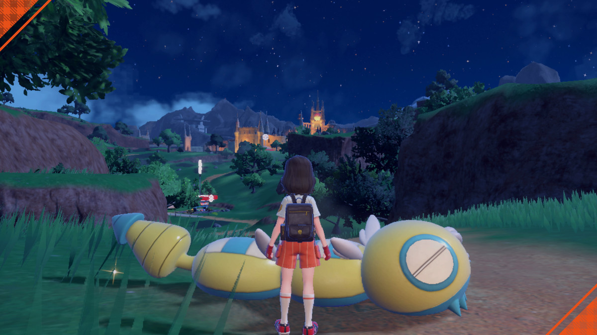 Uno screenshot di un Dudunsparce a un picnic in Pokémon Scarlet and Violet.  È steso a terra e fa sembrare piccolo il trainer in confronto.  Ha quattro segmenti in totale.
