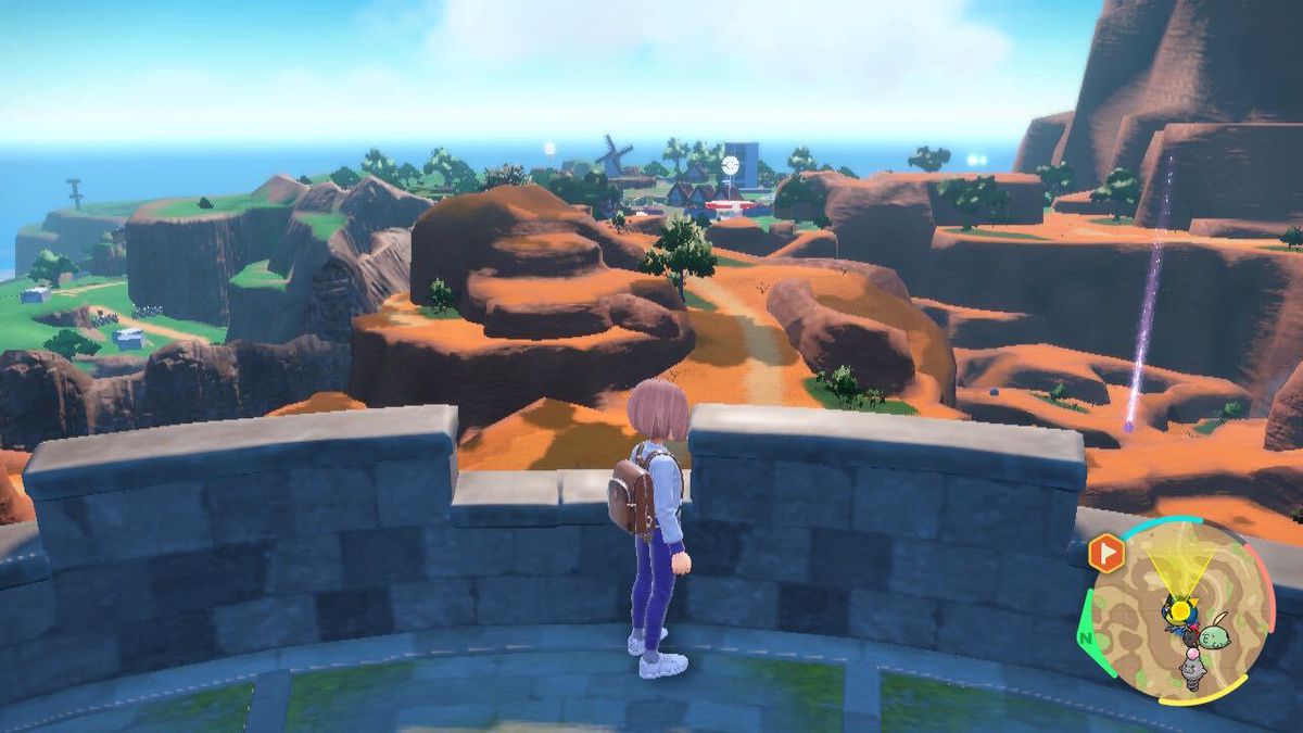 In piedi in cima a una torre di guardia in Pokémon Scarlet e Violet, domina un paesaggio desertico che conduce verso un PokéStop.
