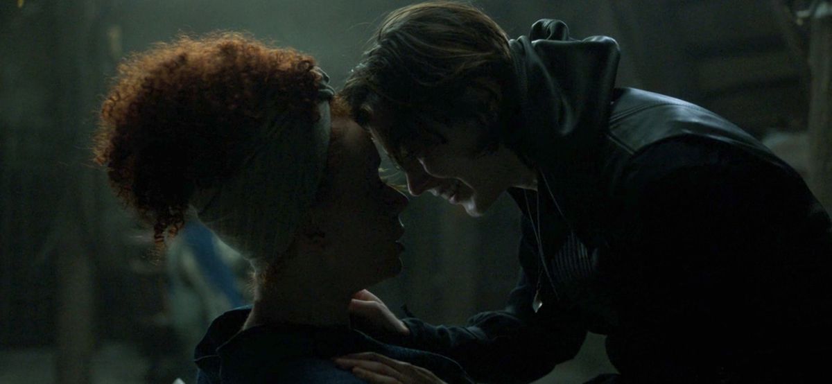 Kit e Jade si abbracciano in una stanza buia a Willow. 