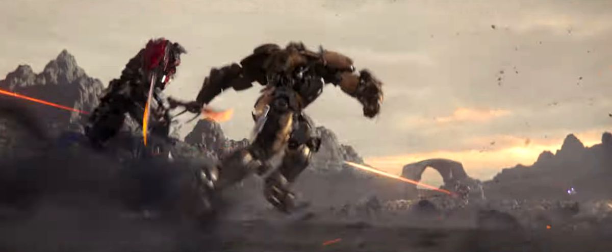 Sfocati Transformers combattono in uno sfondo fangoso marrone in Transformers: Rise of the Beasts