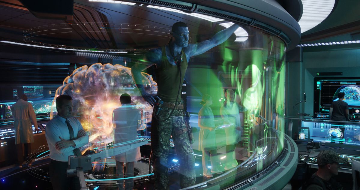 La forma Na'vi del colonnello Quaritch (Stephen Lang) si trova in un centro di comando circondato da umani e guarda un elaborato display VR in Avatar: The Way of Water.