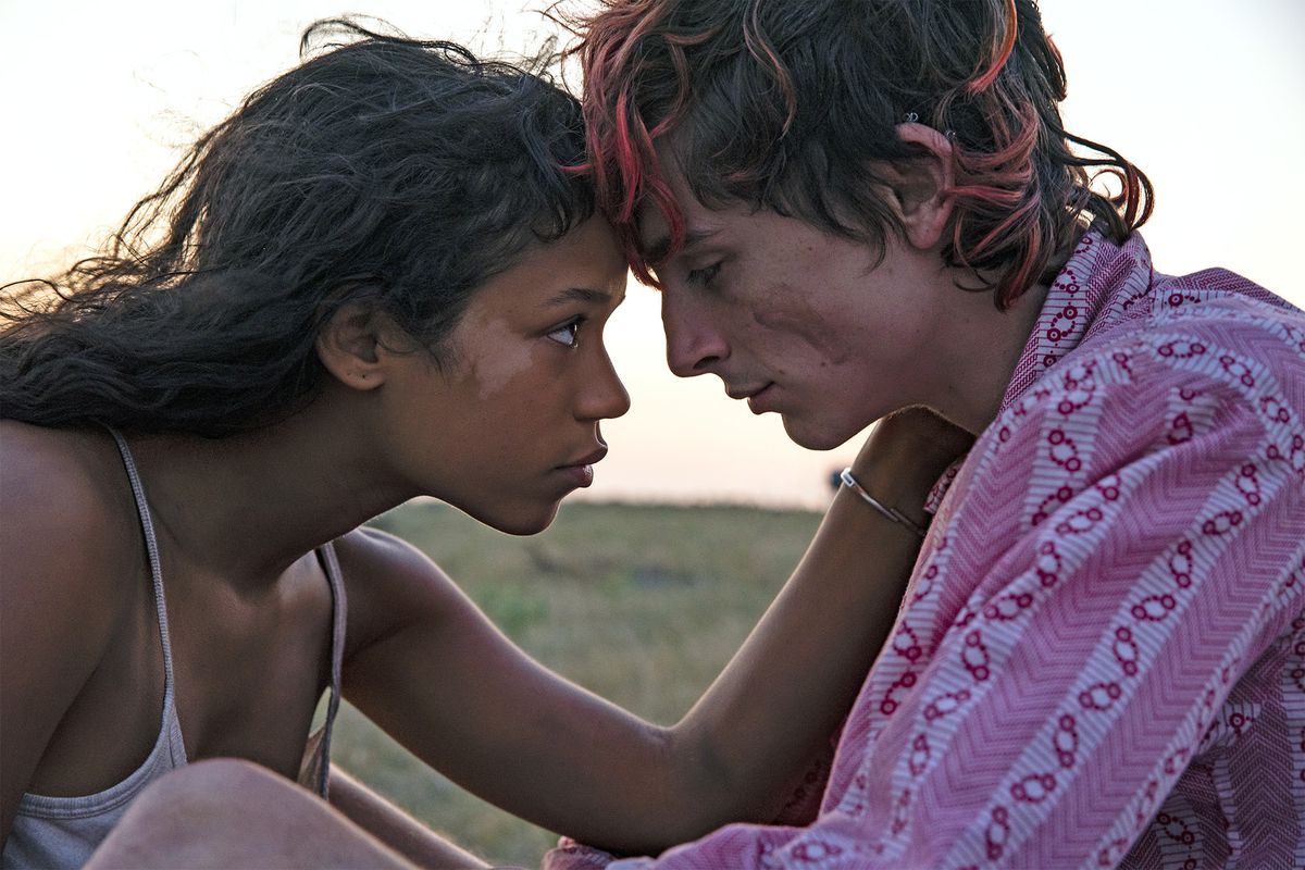 Una giovane donna (Taylor Russell) appoggia la fronte contro un giovane uomo (Timothee Chalamet) con ciocche di tintura rosa tra i capelli.