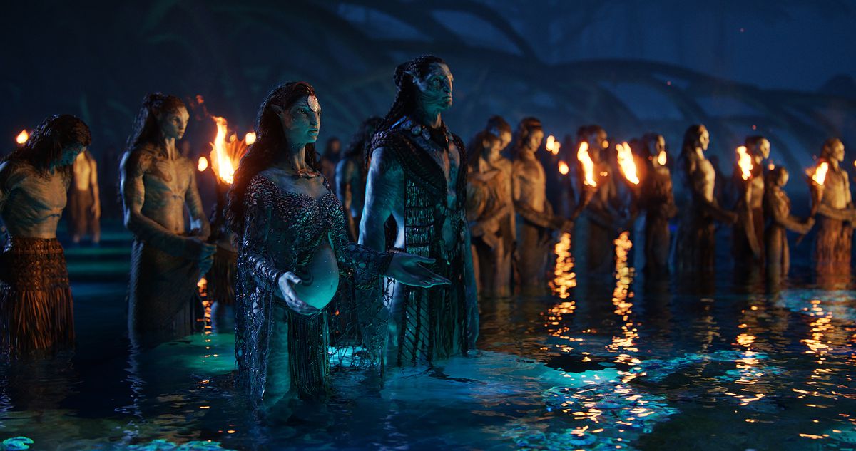 Un gruppo di Na'vi si riunisce di notte per una cerimonia, in piedi nell'acqua fino alle ginocchia e con in mano torce, con Na'vi interpretato da Kate Winslet e Cliff Curtis che presiede, in Avatar: The Way of Water