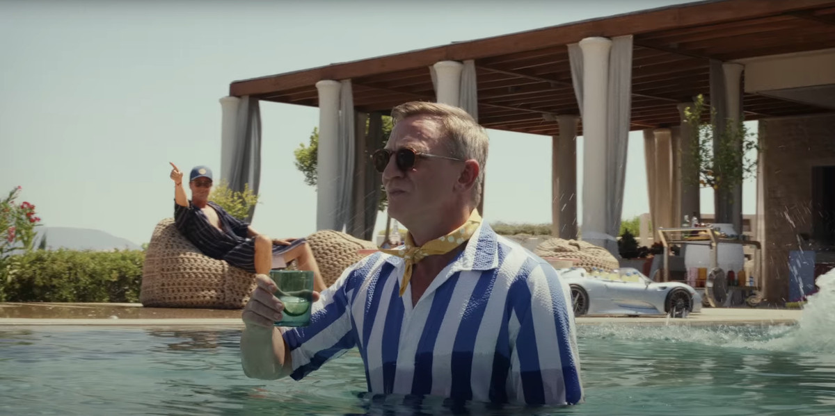 Daniel Craig nei panni di Benoit Blanc in piedi in una piscina con in mano un drink in Glass Onion: A Knives Out Mystery