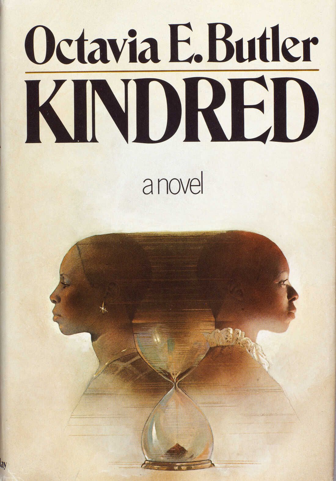 Due donne nere in piedi con le spalle rivolte l'una all'altra che svaniscono l'una nell'altra con una clessidra tra di loro sulla copertina di Octavia Butler's Kindred