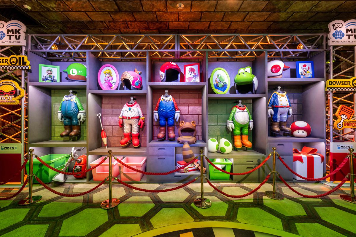 Una foto dal giro di Mario Kart di Super Nintendo World, che mostra gli abiti da kart e il casco di Mario, Luigi, Peach, Yoshi e Toad.