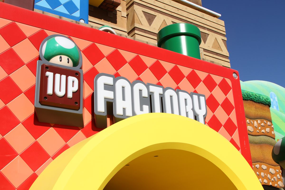L'insegna e l'ingresso ispirato al Warp Pipe per il negozio di articoli da regalo di Super Nintendo World, chiamato 1-Up Factory.