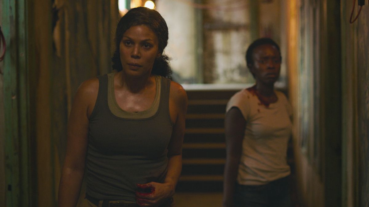 Marlene e Kim, due lucciole, rimangono ferite in un corridoio buio di fronte alla telecamera nella serie HBO The Last of Us