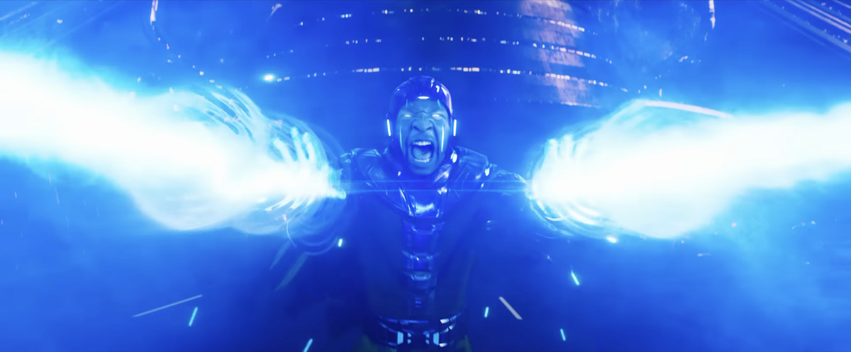 Kang (Jonathan Majors) ruggisce e spara raggi di energia blu dalle sue mani.  L'energia tinge il suo viso dello stesso colore della sua ispirazione fumettistica e fa risplendere le cuciture verticali sul suo viso, in Ant-Man & the Wasp: Quantumania.