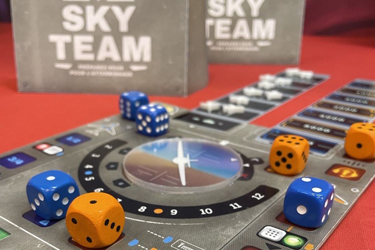 Una prima immagine di un modello di pre-produzione di Sky Team, che include un disco di plastica per un giroscopio, dadi blu e gialli e un mockup di altra strumentazione in cartone.