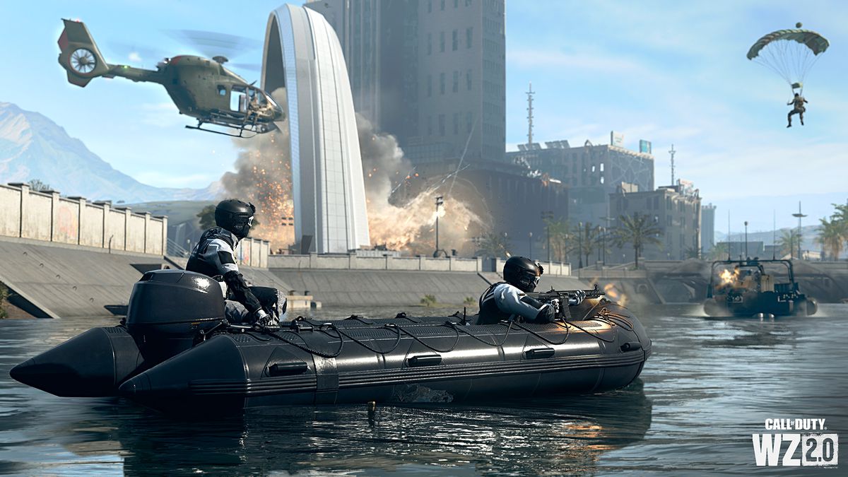 Due giocatori che indossano skin a pagamento combattono in un fiume ad Al Mazrah.  Un elicottero si muove sullo sfondo mentre una barca blindata si avvicina.  Un altro giocatore galleggia sopra un paracadute.