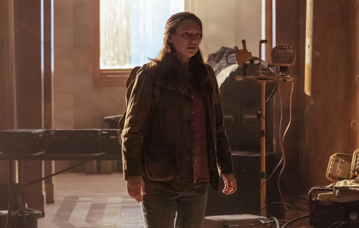 Tess è in piedi con il suo zaino in un atrio abbandonato un tempo utilizzato come ospedale improvvisato in The Last of Us