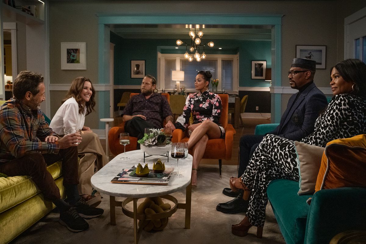 Le famiglie Cohen e Muhammed siedono insieme in un salotto con goffa cortesia in una scena di You People di Netflix. 