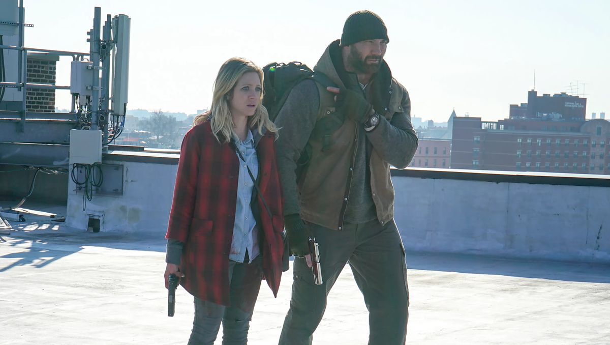 Dave Bautista e Brittany Snow camminano su un tetto in una fredda mattina di New York e impugnano le pistole a Bushwick.