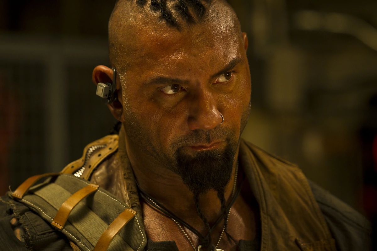 Dave Bautista è lucido di sudore in un'uniforme militare in Riddick.