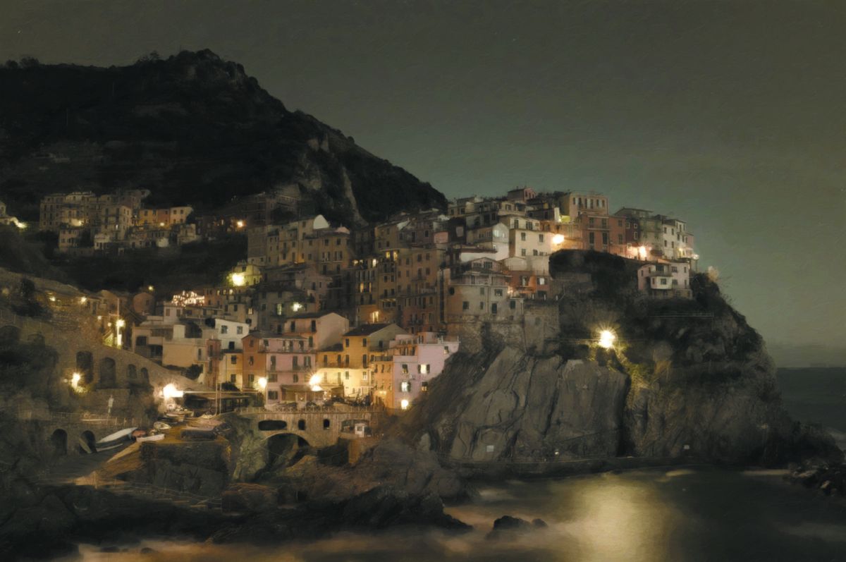 Un villaggio italiano su una scogliera.  È notte e la luce gialla proietta strane ombre sulla terra.
