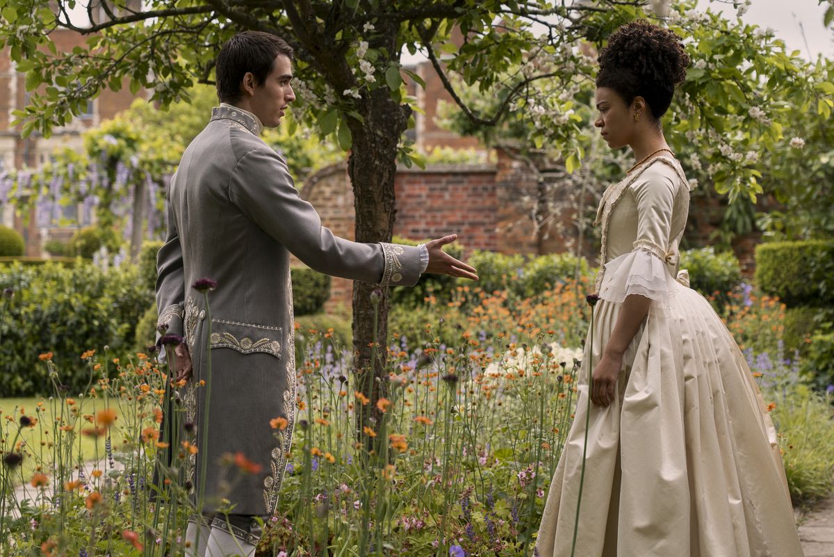re giorgio offre una mano a una giovane regina charlotte in un giardino