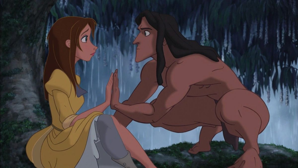 Tarzan accovacciato sul ramo di un albero, premendo la sua mano contro quella di Jane.  indossa un abito giallo gonfio.  indossa solo un perizoma.  sta piovendo