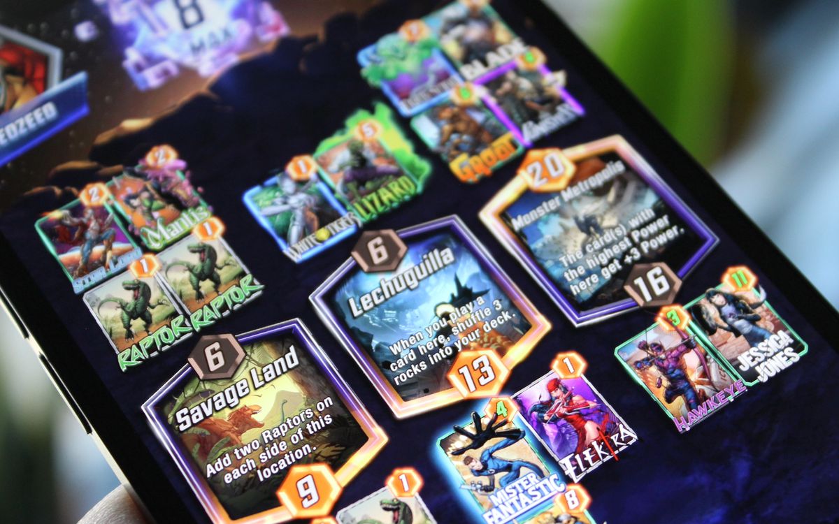 Una foto di un gioco di Marvel Snap, con i luoghi Savage Land, Lechuguilla e Monster Metropolis, e varie carte, su un iPhone.