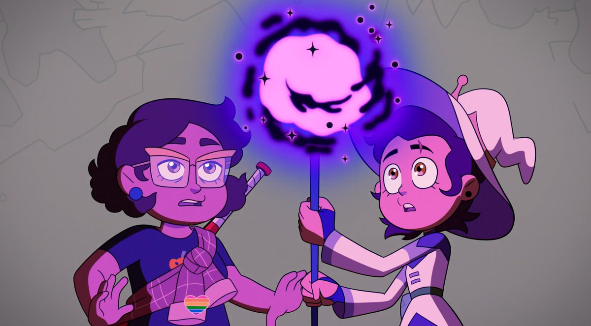 Luz tiene in mano un bastone viola con una sfera luminosa all'estremità.  Lei lo guarda con soggezione.  Accanto a lei, anche sua madre Camila sembra stupita