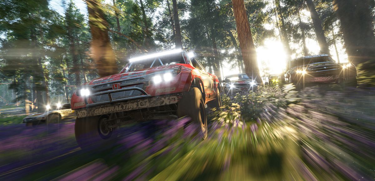 Forza Horizon 4: veicoli fuoristrada con luci accese attraversano una foresta aspra
