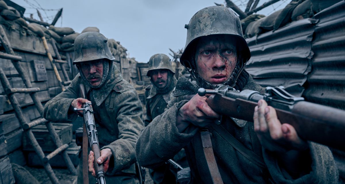 Tre soldati imbrattati di sangue e fango navigano timorosi in una trincea della prima guerra mondiale con i fucili puntati nel candidato per il miglior film di Netflix Tutto tranquillo sul fronte occidentale