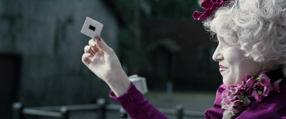 Effie Trinket mostra un foglietto al Reaping, registrato nel film The Hunger Games. 