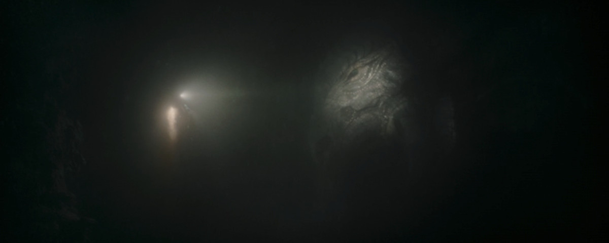 Bo-Katan nuota e punta la torcia sul mitosauro in uno screenshot dell'episodio 2 stagione 3 di The Mandalorian