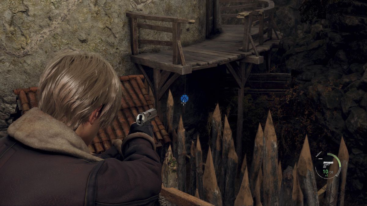 Leon S Kennedy mira a un medaglione blu appeso sotto un passaggio nell'area della Fattoria del remake di Resident Evil 4