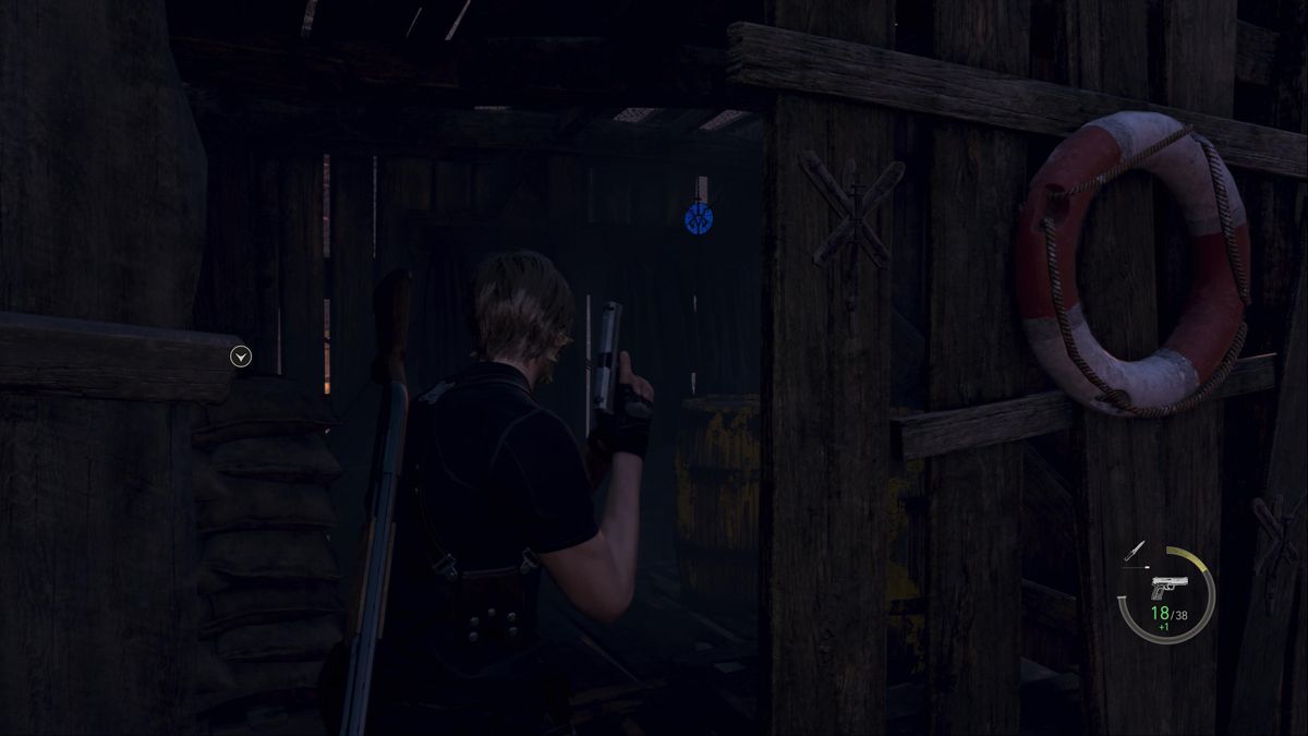Leon S Kennedy mira a un medaglione blu all'interno di una baracca nell'area dell'allevamento ittico nel remake di Resident Evil 4