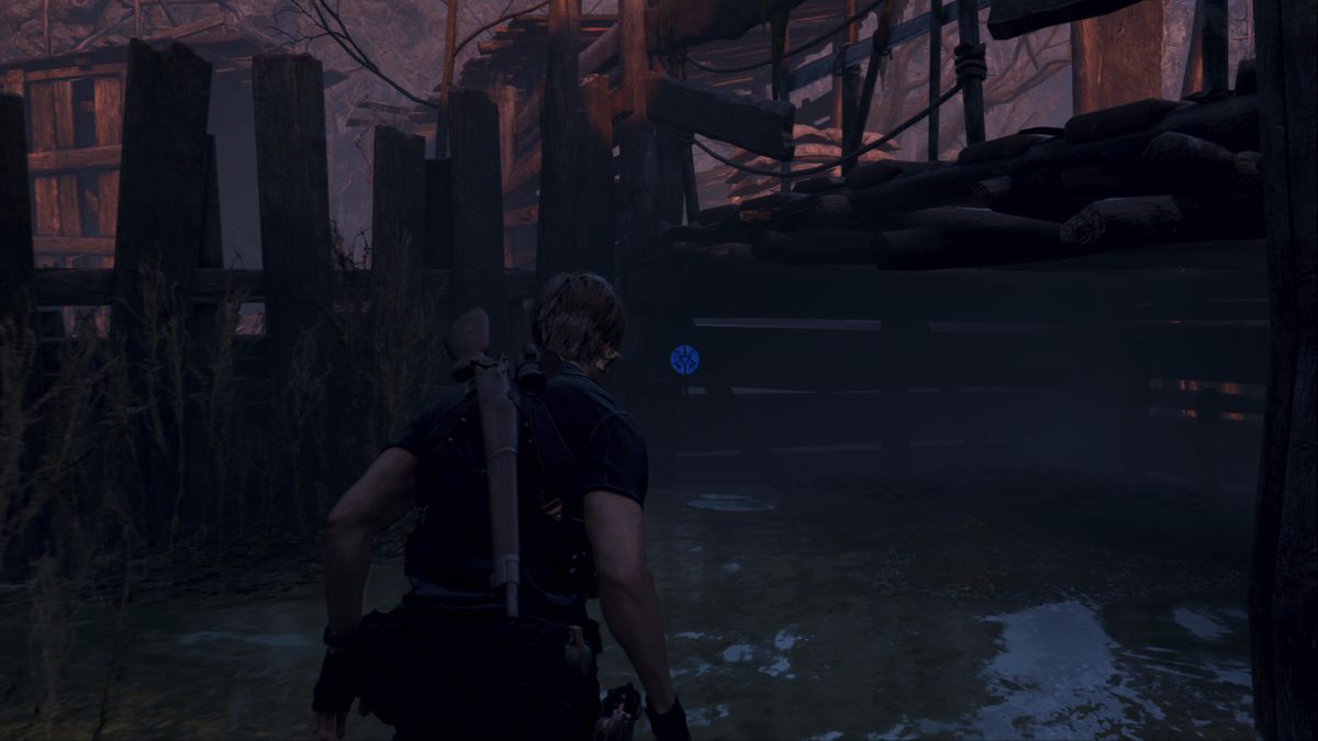 Leon S. Kennedy si trova di fronte a un medaglione blu sotto una passerella nell'allevamento ittico nel remake di Resident Evil 4