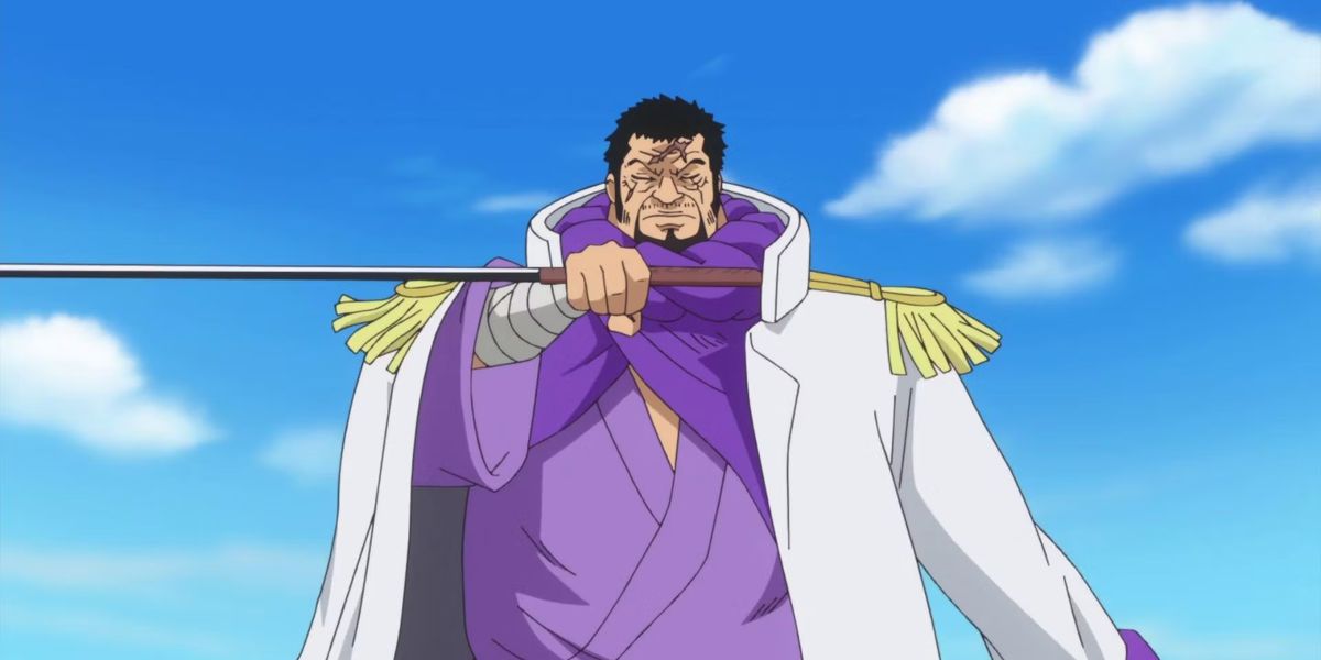 Fujitora tiene una spada di traverso in un unico pezzo, indossa una giacca bianca, una veste viola e con gli occhi chiusi.