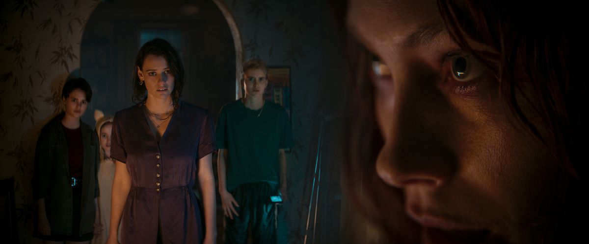 Beth (Lily Sullivan) affronta nervosamente la sua sorella dall'aspetto disturbato Ellie (Alyssa Sutherland) mentre i tre figli di Ellie si stringono dietro di lei in una porta buia in Evil Dead Rise