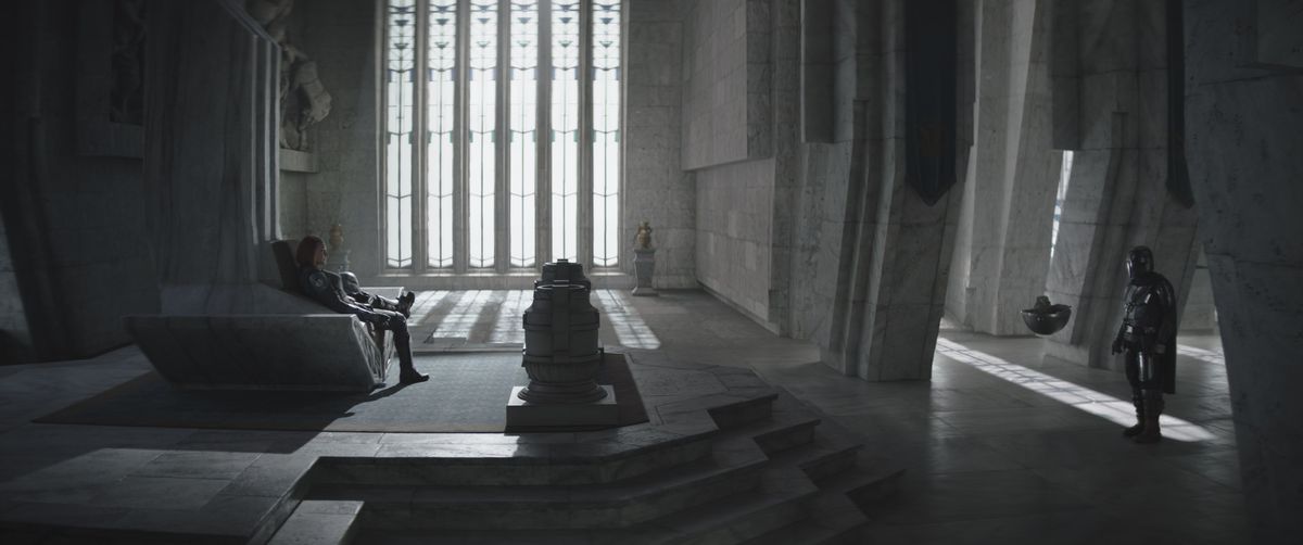 Bo-Katan (Katee Sackhoff) seduta sul trono con il Mandaloriano (Pedro Pascal) e Grogu che la guardano