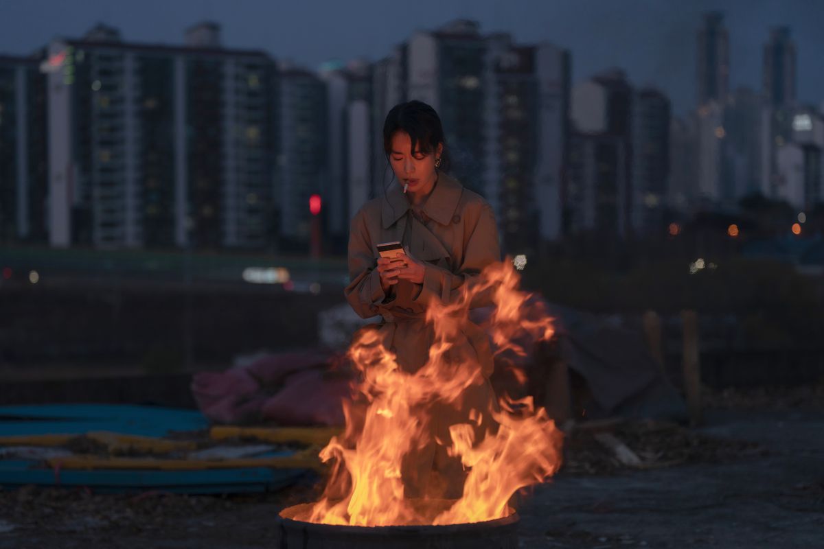Im Ji-yeon nei panni di Park Yeon-jin in piedi davanti a un fuoco che guarda il suo telefono