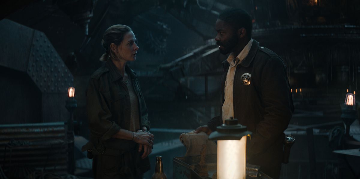 Una donna (Rebecca Ferguson) si trova di fronte a un uomo (David Oyelowo) che indossa un distintivo da sceriffo in un buio ambiente industriale fiancheggiato da lanterne futuristiche.