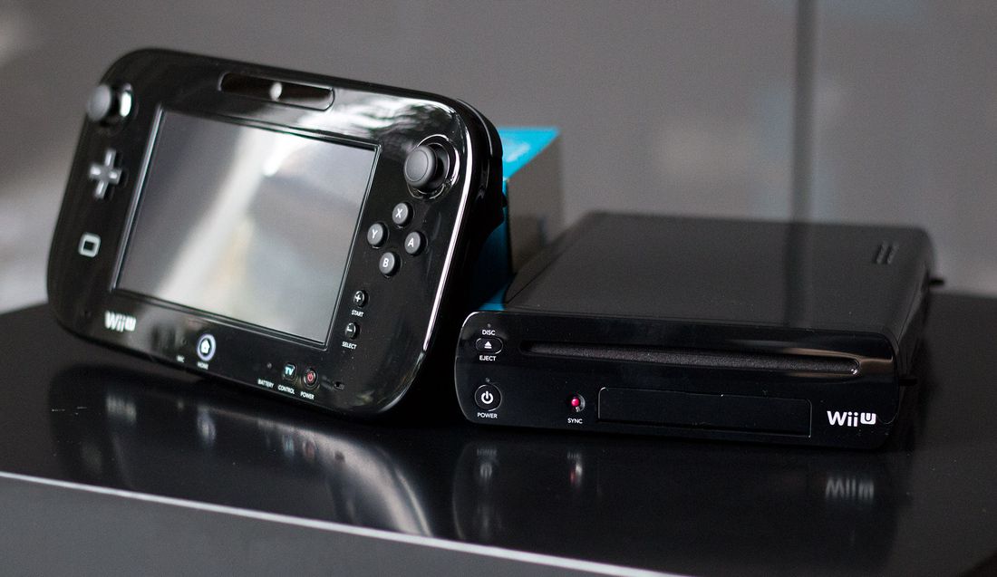 Un Wii U GamePad e una console neri si trovano su una superficie lucida.