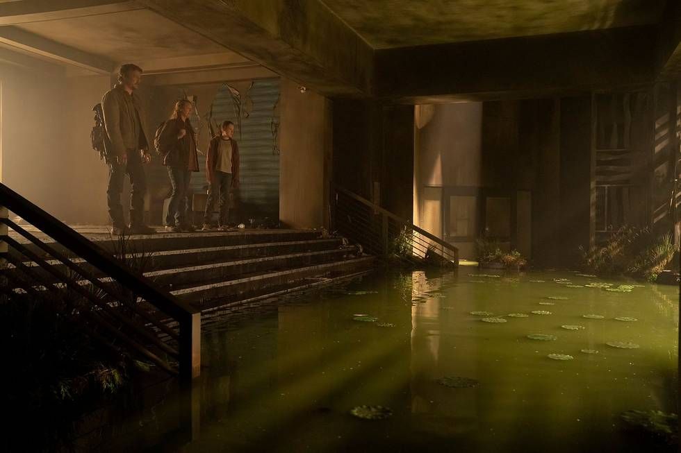 Joel (Pedro Pascal), Tess (Anna Torv) ed Ellie (Bella Ramsey) si trovano in cima a una piccola scala della hall di un hotel che è stata allagata