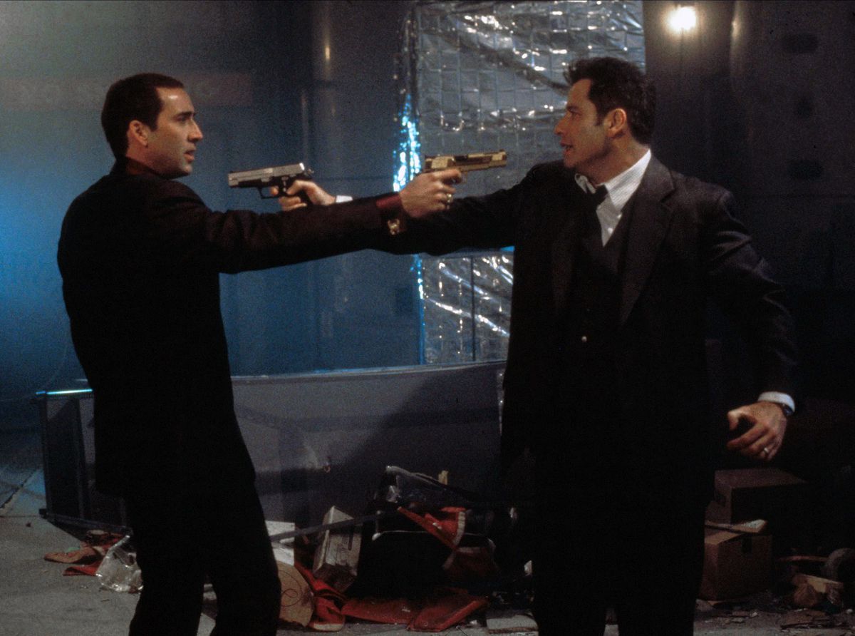 I due uomini in Face/Off si affrontano, puntandosi le pistole l'un l'altro.