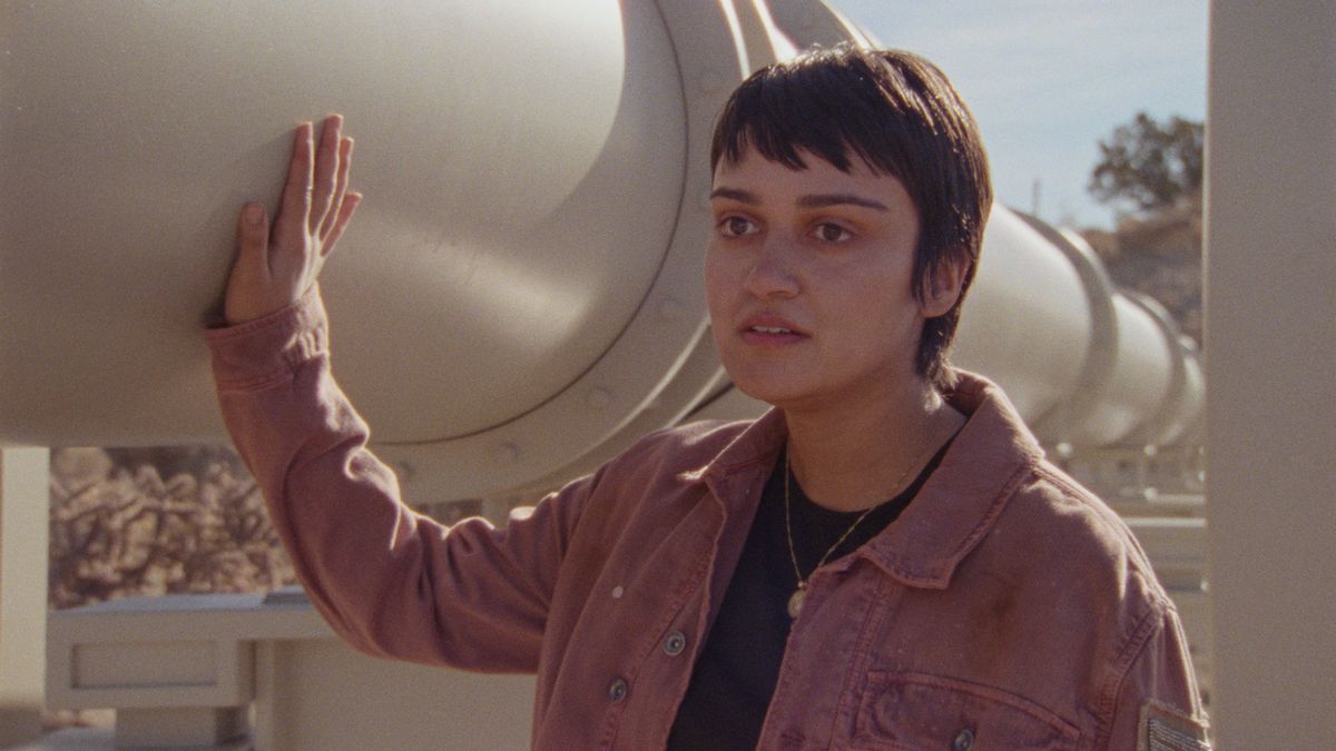Xochi (Ariela Barer) fa scorrere la mano lungo un oleodotto in How to Blow Up a Pipeline