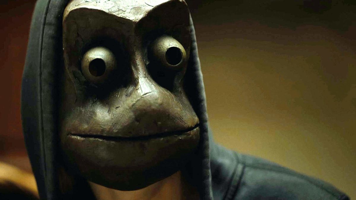 Un uomo che indossa una terrificante maschera da rana in una felpa con cappuccio nera in I See You.