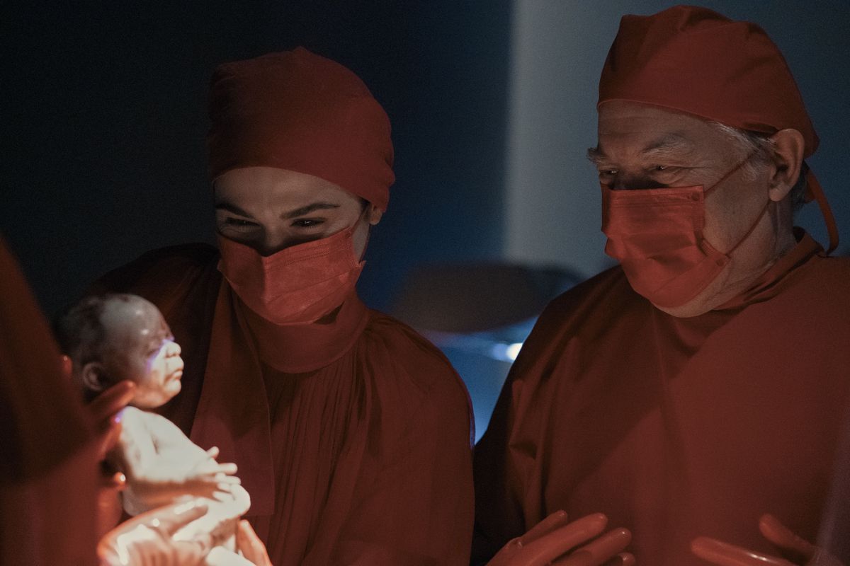 Elliot Mantle (Rachel Weisz) tiene in braccio un neonato con un altro dottore (Michael McKean) che le guarda alle spalle