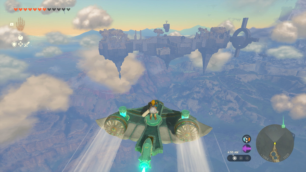 Link guida un aliante/aereo improvvisato, alimentato da batterie Zonai, verso un'isola in lontananza in The Legend of Zelda: Tears of the Kingdom